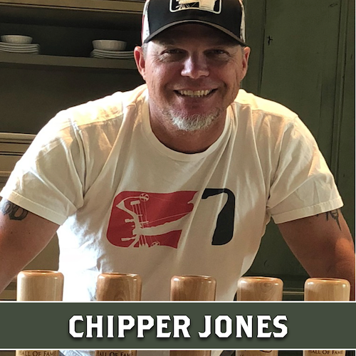 Chipper Jones displaying 4 wooden Dugout Mugs baseball bat mugs, with his name displayed in a banner at the bottom.