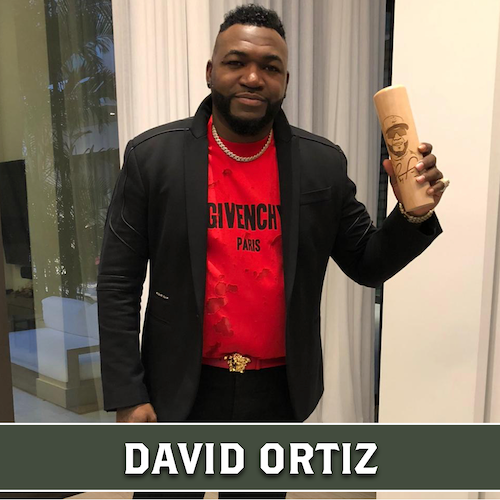 David Ortiz holding a tall, cylindrical wooden Dugout Mugs mug with a carved design, with his name displayed in a banner at the bottom.
