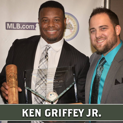Ken Griffey Jr. holding a wooden Dugout Mugs baseball bat mug and an award 