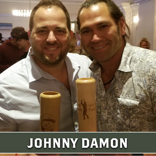 Johnny Damon posing beside another man, both holding wooden Dugout Mugs baseball bat mugs.